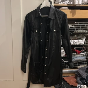 Skjortjacka - Svart skjortjacka i läderimitation från nakd. Aldrig använd, lappen kvar