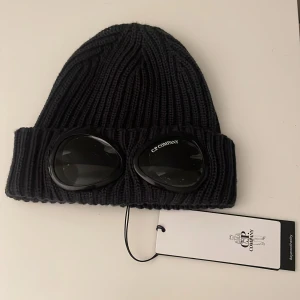 C.P.Company - Helt ny mössa från C.P. Comapny i mörkgrå färg. Endast testad ett fåtal gånger, har fortfarande plasten och lappen kvar. Pris går att diskuteras💞