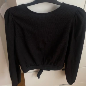 Svart blus från Monki - Säljer den här gulliga blusen från Monki. Den håller fint skick och är endast använd vid fåtal tillfällen. Det är storlek S.