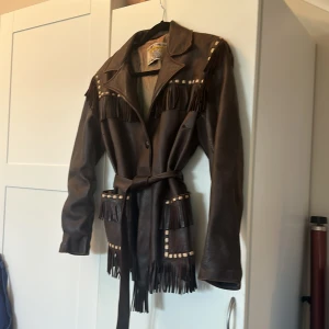 Brun Läderjacka med fransar - Säljer denna fantastiskt fina läderjacka som jag köpte på second hand men aldrig fått användning för.