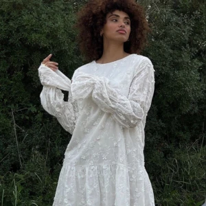 Klänning med ärmdetalj - NAKD - En jätte fin vit blomning klänning med ärmdetalj, perfekt till studenten. Den är helt oanvänd med alla prislappar kvar. 