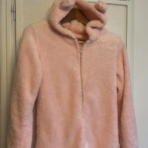 Rosa fluffig one piece med öron🐻 - Super gullig rosa fluffig one piece med öron på luvan!🐻💕