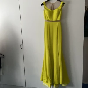 Vacker grön aftonklänning  - -Ser ut som tvådelad klänning med överdel och lång kjol, meshtyg vid axlarna  -Åtsittande från axlarna ner till låren, har en slit som börjar precis över knäet.  -Passar XS/S, använde klänningen med högklackat (10+cm) -Använts max 3 ggr