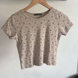 Säljer denna fina ljusrosa T-shirten med blommor på från brandy Melville i storlek S/M. Ganska bra skick, kan diskutera pris💕