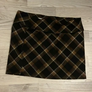 brun plaid kjol -  jättefin kjol från h&m! använd cirka 2-3 gånger så den är i jätte fint skick! säljer för att den är för liten för mig. köparen betalar frakt!
