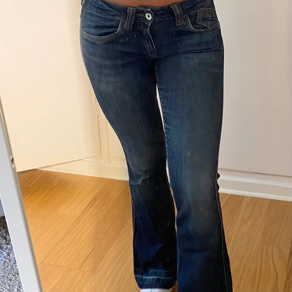 Lågmidjade jeans från Tommy Hilfiger, midjemått: 70cm, innebenslängden: 75cm, se slitage längst ner på byxan. Jeans & Byxor.