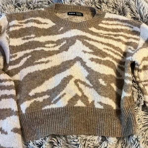 Mönstrad stickad tröja  - En super skön Beige och vit zebra mönstrad stickad tröja, har knappt aldrig använt den! 