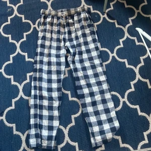 Rutig mjukisbyxor - Ett par bekväma mjukisbyxor med ett rutigt mönster i blått och vitt. Byxorna har en elastisk midja med snörning för justerbar passform.