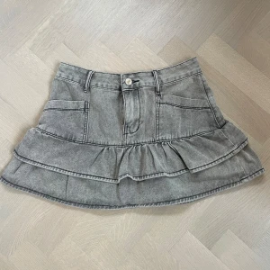 Volang jeanskjol - Jättefin jeanskjol med volanger i en ljusgrå färg! Aldrig använd och är i storlek M men är ganska stretchig så den passar Xs-M skulle jag säga. Vet inte vart den är ifrån tyvärr
