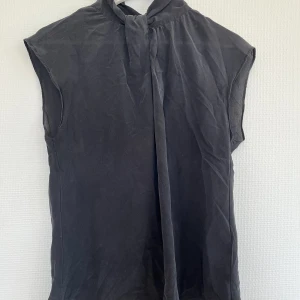 Svart blus - Svart blus från Sand men är köpt second hand men där efter bara använt den en gång. Jätte fint skick. Det står inte vilken storlek det är men skulle uppskatta att det är ungefär storlek S efter som att den passar mig som vanligtvis bär storlek S.