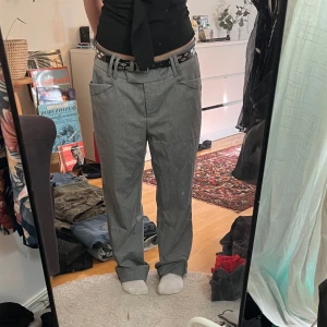 Grå kostymbyxor - Gråa baggy kostymbyxor som är lite för stora för mig i midjan. Inga defekter.  Står 44 men skulle säga att de passar 38-44 beroende på hur man vill att de ska sitta. Med bälte sitter dem bra på mig. 