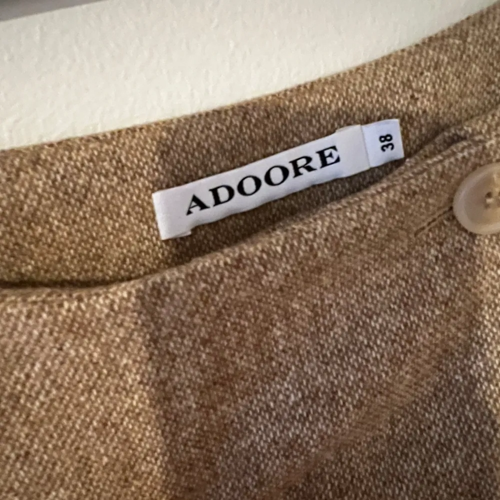 Suit skirt i strl 38 från Adoore. Endast testad, aldrig använd. Finns en croppad blazer som passar till fortfarande i lager hos adoore: https://adoore.se/products/cropped-blazer-beige-melange. Kjolar.