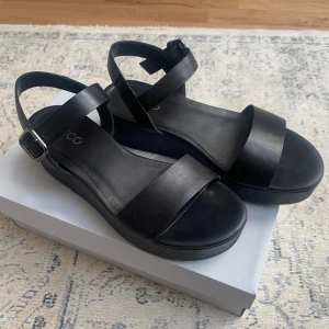 Ecco sandaler svart läder - Varsamt använda ecco sandaler med tjock sula. Små tecken på användning men inget som märks när man sätter på sig sandalerna. Meddela om frågor eller fler bilder