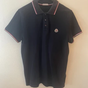 Moncler piké  - Säljer en riktigt snygg moncler piké som är väldigt mörk blå, den är använd fåtal gånger, köptes på nk förra året. Tveka inte på att höra av dig vid funderingar🙌🏻