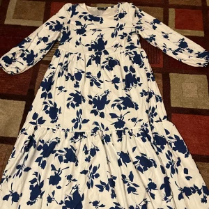 En jättefin blommig sommarklänning  - En jättefin blommig sommarklänning i vit och blå, som är perfekt nu till vår och sommaren.  Den är s men skulle säga att passar även M🤗🥰
