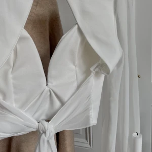 Vacker vit topp - Absolut finaste vita toppen någonsin, med öppen rygg och band som knyts baktill. Väldigt elegant, och passar till allt. Köpt i Paris, stl s-m.❣️