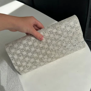 Clutch väska - Clutch/ portmonnä i silverstrass. Perfekt till bal eller finsittningar😍 har spännen att stänga med, innerfack och går att sätta fast axelband om man skulle vilja