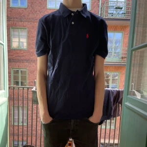 Polo piké svart med röd logga - Aldrig använd. Helt ny och fräsh! 