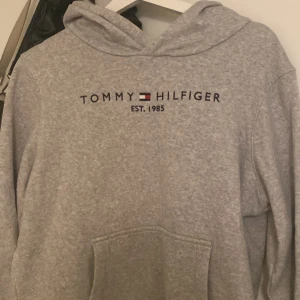 En snygg Tommy Hilfiger hoodie  - En grå hoodie från Tommy Hilfiger i storlek S. Den är i bra skick. Säljer pågrund av att jag inte använder den längre och har många hoodies.