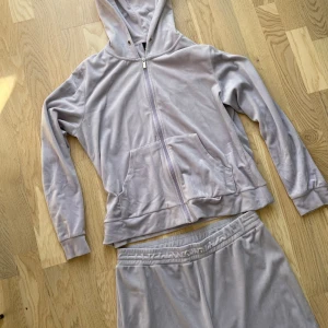 Gina velour set ljuslila - Superfint velour set med hoodie och byxor (banden är borta på båda som ni ser på mina bilder). Verkligen nyskick då det inte använts mycket 💜