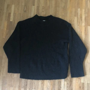 Svart ribbstickad tjocktröja - Säljer denna svarta tjocktröja från Lindex. Aldrig använd och är i fint skick. Den är ribbstickad och har en liten krage.
