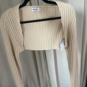 Bolero - Bolero med extra långa och pösiga ärmar. Finstickad i en kall beige färg. Är i storlek XXS men skulle säga att den lika bra passar XS och S. Perfekt med ett linne under eller över en sommarklänning💕