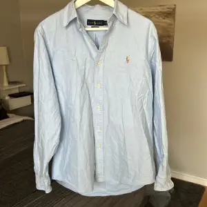 En ljusblå Polo Ralph Lauren skjorta i felfritt skick! M classic fit, skulle dock säga att fen sitter mer åt det slimmade hållet. Nypris runt 1700kr, säljes då den ej kommer till användning.