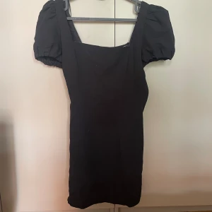 Svart kort klänning från Zara - Svart kort klänning från Zara. Puffärmar och knytning i ryggen. Jättefin med tyvärr för liten för mig :(