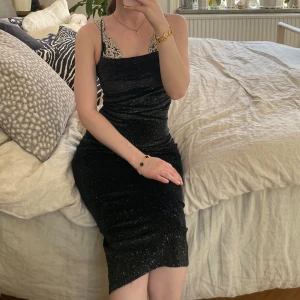 Glittrig klänning  - Svart glittrig midi klänning. Storlek XXS/32