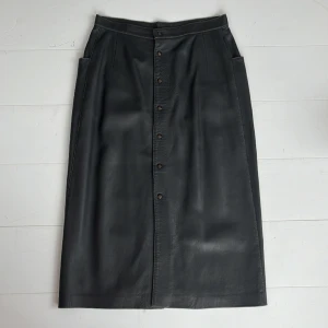 Skinnkjol - Snygg vintage skinnkjol i grått. Slutar vid vaderna. St 38 men funkar om man har st 36 oxå. Midjemått 36,5 cm rakt över, längd 74,5 cm. 