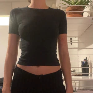 Svart tajt topp kortärmad - Mjukt stretchtyg, inget slit. Märket mexx. Strl S