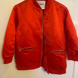 Carin Wester - Underbart röd bomberjacka i strl S från Carin Wester. Grov kedja fickor. Material 100% polyester. Går att tvätta i 40. 