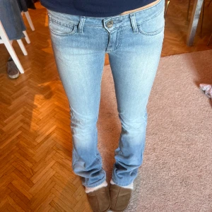 Blåa lågmidjade jeans  - Lågmidjade bootcut jeans med fickor inbak! Supersnygga från Wrangler 