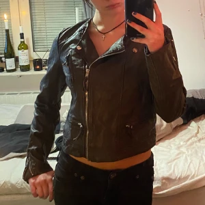 Brun skinnjacka - Så snygg mörkbrun skinnjacka som inte används längre. Storlek 38 och sitter inte så tajt som jag hade önskat, bär vanligtvis s/xs. OBS. Ena knappen på kragen är sönder och det finns några sprickor på insidan av jackan (se bild 3)