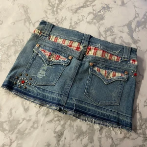 Lågmidjad jeanskjol - En jätte unik jeanskjol i storlek 10 som är xs. Den har fina detaljer med stretchig midja. Den är 40 cm rakt över och 30cm lång, passar mig som har xs❤️😍😍 skriv till mig för intresse!!