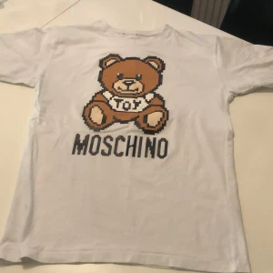 Moschino set - T-shirt och shorts   t-shirten är vit  shortsen grå. 