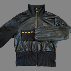 Y2K adidas x Missy Elliot ”Respect me” tjocktröja  - Adidas tjocktröja från kollektionen ”Respect me” med Missy Elliot, fina guld detaljer samt svarta glitterstenar på baksidan.