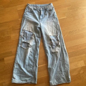Slitna jeans - Blå jeans med hål i. Sitter skönt på kroppen