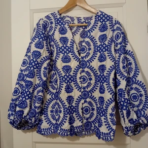 Blus/ tunn jacka - Blå-vit blus/ tunn jacka/kofta Strl L bommull med blå broderier. Helt ny o oanvänd.  Rök o djurfritt hem