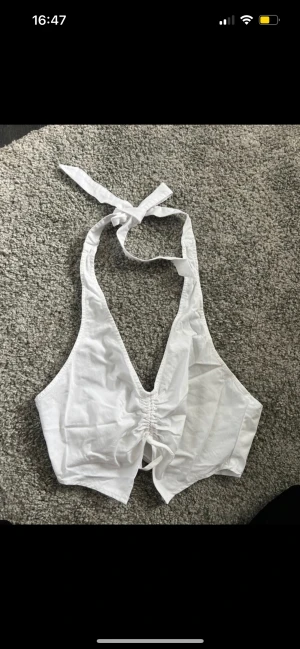 Halterneck Topp - Superfin och aldrig använd. Snygga detaljer framtill och är snygg på