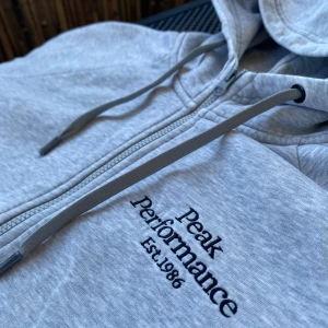 Zip hoodie  - En väldigt fin zip hoodie ifrån peak performance, men tyvärr så är den väldigt sliten så säljer billigt!
