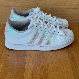 Adidas superstar  - Använda men i gott skick. Vita med rosa skimrande ränder. Storlek 33 1/2
