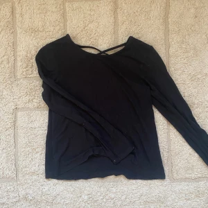 Blus - Svart blus med visande rygg.