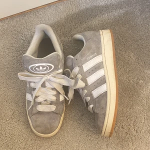 Adidas campus 00 - Trendiga gråa adidas campus 00 i storlek 42. Vällanvända men lätta och rengöra utöver smuts så är det inga större skador. Nypris 1599kr mitt pris 1300kr plus frakt 😊