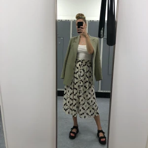 Mönstrad kjol stl S - Mönstrad kjol i svart och off-white med knappar framtill och resår i midjan  Storlek: S Material: 100% bomull. Väldigt luftig och skön på sommaren! 