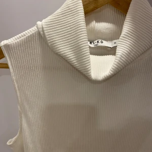 Vit polotröja utan ärmar - En vit polotröja utan ärmar som är köpt för ett par år sedan från NA-KD✨ Slutade använda den för ett tag sedan då jag tyvärr tyckte inte om hur den satt på mig längre. Den är både elastisk i materialet och tight så den funkar även som mindre storlek 