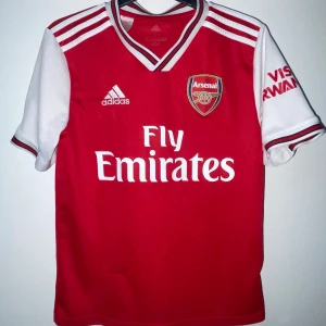 Arsenal 19/20 Home Jersey - Otroligt fint skick, endast den lilla grejen i bild där tråden åkt ihop (nere mot vänster)