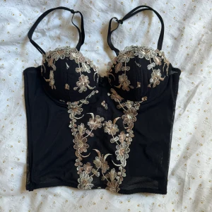 Korsett topp - Så fin topp med blommiga detaljer i bra skick. Finns i tre olika nivåer att spänna där bak och banden kan man även ändra. Skulle säga att den passar en B-kupa också!💖