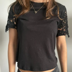 Svart T-shirt med spetsärmar - Jättefin svart T-shirt med spetsärmar. Köpt för 250kr från mango och säljer för att den inte kommer till användning. Säljer en likadan i vit❤️