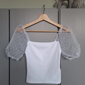 Vit topp med puffärm, meshärm, spetstopp strl XS  - Vit topp med puffärm, meshärm, spetstopp strl XS. Djurfritt och rökfritt. 